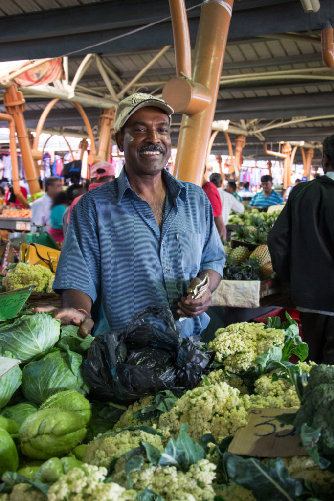 Ein freundlicher Händler auf einem Markt auf Mauritius