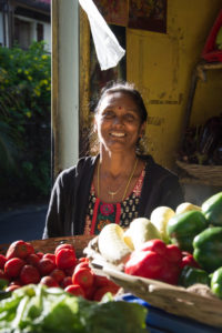 Eine Verkäuferin an einem Gemüsestand auf Mauritius