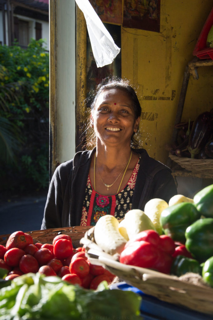 Eine Verkäuferin an einem Gemüsestand auf Mauritius