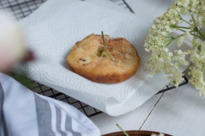 Die Holunderblütenküchlein tropfen auf Küchenkrepp noch etwas aus
