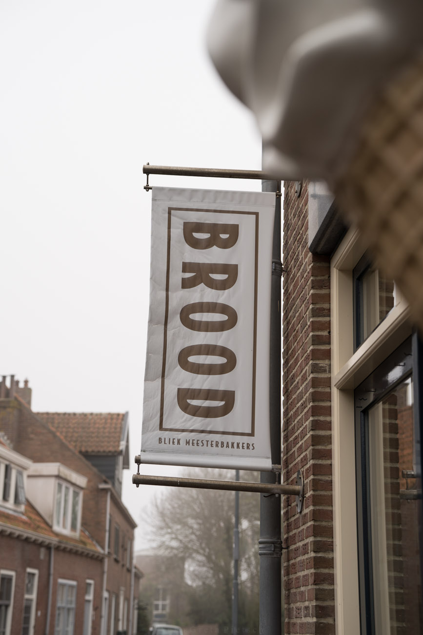 Ein Plakat an einer Hausfassade mit dem Aufdruck "BROOD". Ein Schild für eine Bäckerei in den Niederlanden.