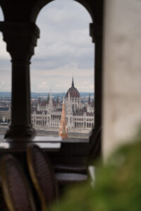 Der Blick durch Torbögen von der Fischerbastei aus auf das Parlamentsgebäude, Budapest, Ungarn
