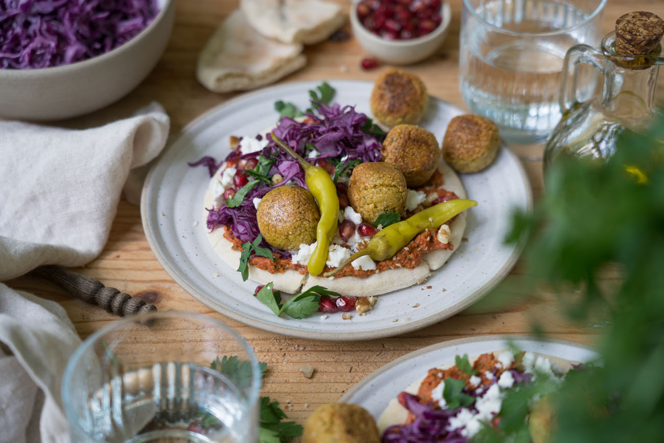 Bunt belegte Pitas mit allerlei leckeren Zutaten wie Falafel, Rotkohl-Salat, Peperoni, Petersilie, Granatapfelkernen.