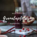 Ein Titelbild für einen Blogbeitrag mit der Aufschrift "Granatapfelsirup" - man sieht ein kleines Fläschchen mit dem Sirup dahinter