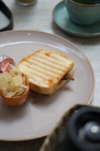 Ein gegrillter glutenfreier Sandwich auf einem hellen Teller