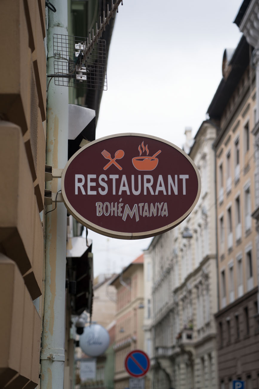 Ein Schild an einer Hausfassade in Budapest mit dem Hinweis für ein Restaurant (BoheMTanya)