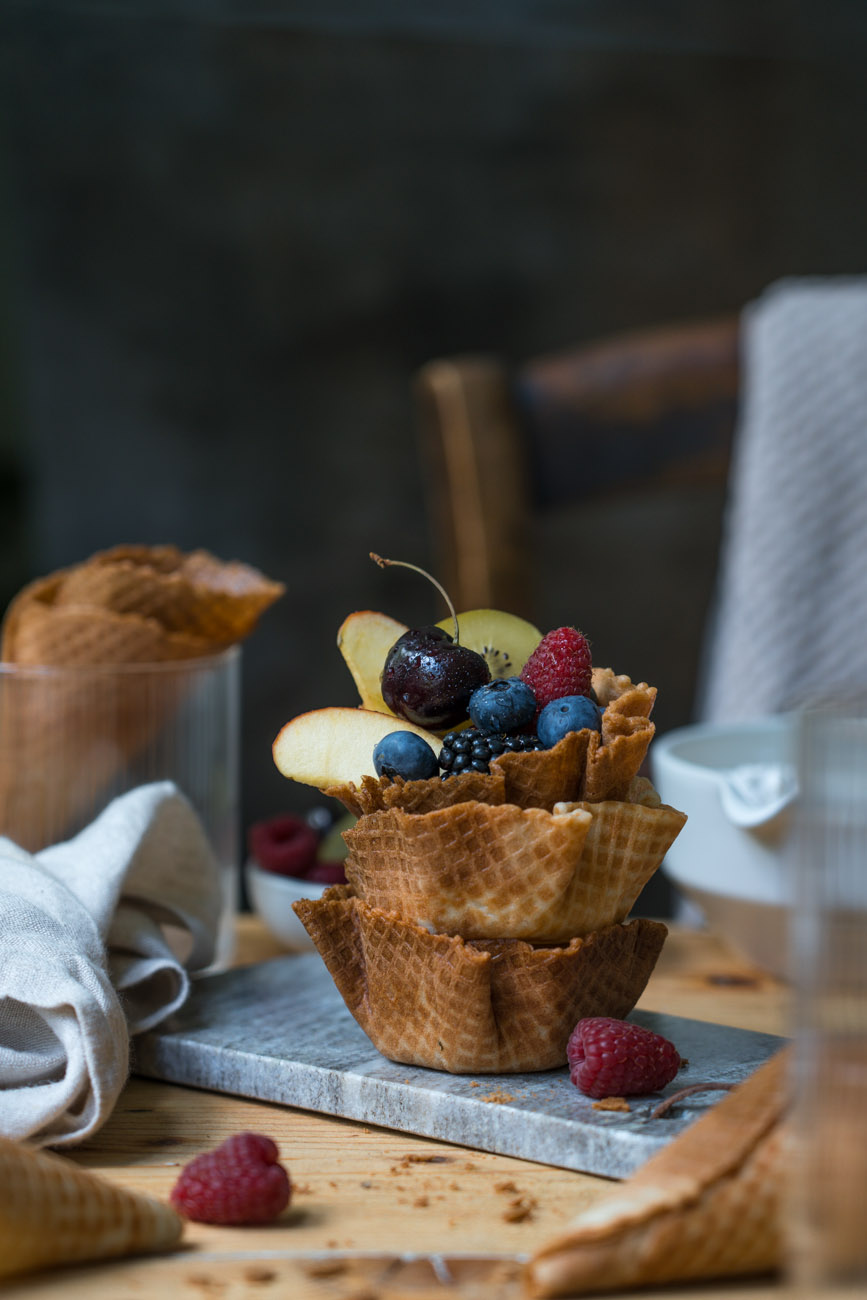 Drei gestapelte Eisschälchen aus knusprigem Waffelteig, mit Obst gefüllt, glutenfrei