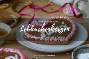 Ein Holztisch mit einem hellen Keramikteller, auf dem ein Lebkuchenherz mit der Aufschrift "Mausi" liegt.
