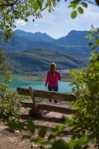 Eine Person steht an einem Aussichtspunkt auf den Kalterer See in Südtirol.