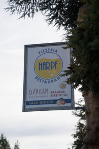 Ein Schild mit dem Hinweis für ein Restaurant "Harpf" in Brixen.