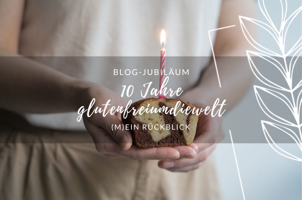 Ein Stück Marmorkuchen, gehalten von 2 Händen, mit einer rosafarbenen Geburtstagskerze, die brennt. Dsrüber liegt eine Schrift "BLOG-JUBILÄUM: 10 Jahre glutenfreiumdiewelt. (M)ein Rückblick.