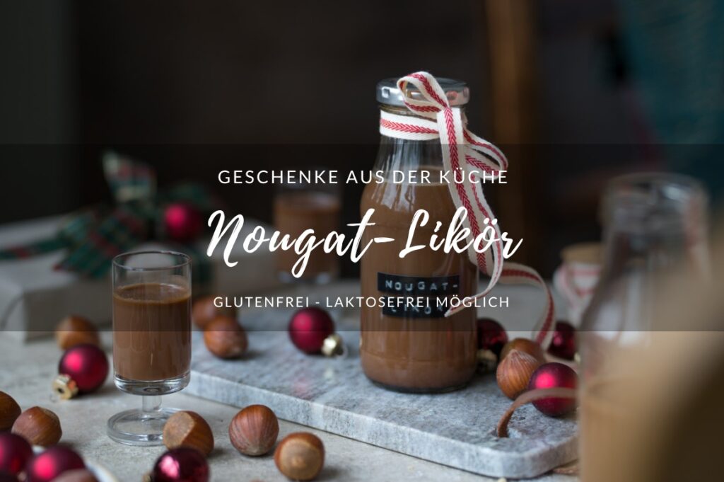 Ein kleines Fläschchen mit Nougat-Likör steht auf einem Marmorbrettchen. An der Flasche ist eine Schleife und der Tisch ist ein wenig weihnachtlich dekoriert.