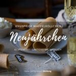 Ein Tisch gedeckt mit Sektgläsern, in der Mitte steht ein Teller mit gerollten, knusprigen Waffeln.