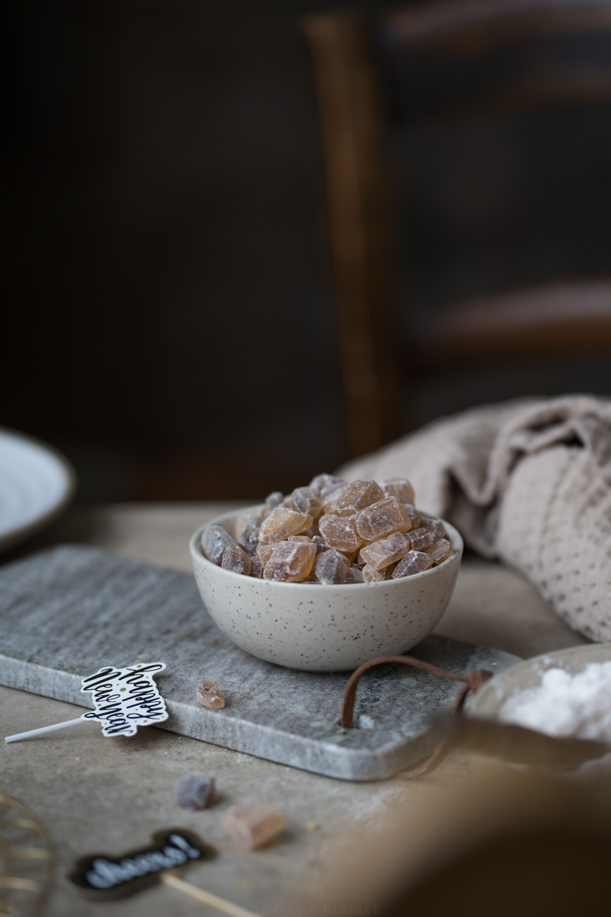 Eine Arbeitsfläche, in der Mitte steht eine Schale mit braunem Kandis.