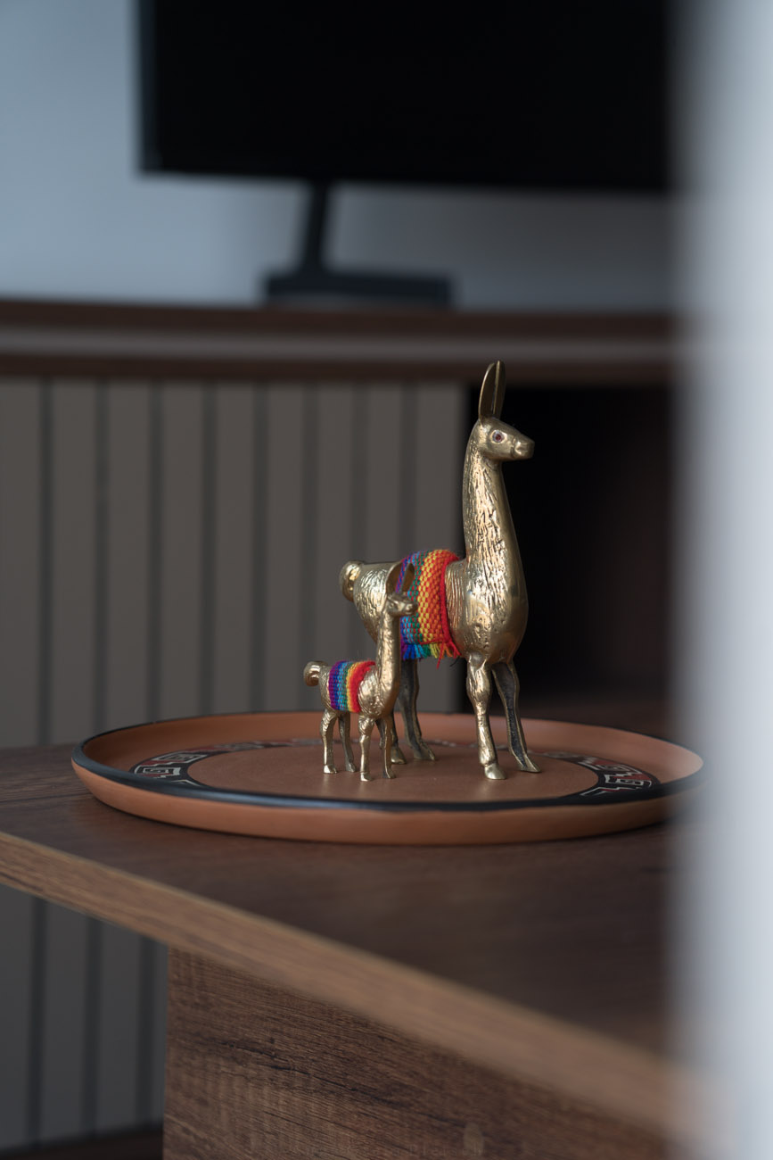 Zwei Lama-Figuren aus Messing stehen auf einem Deko-Tablett auf einem Couchtisch.