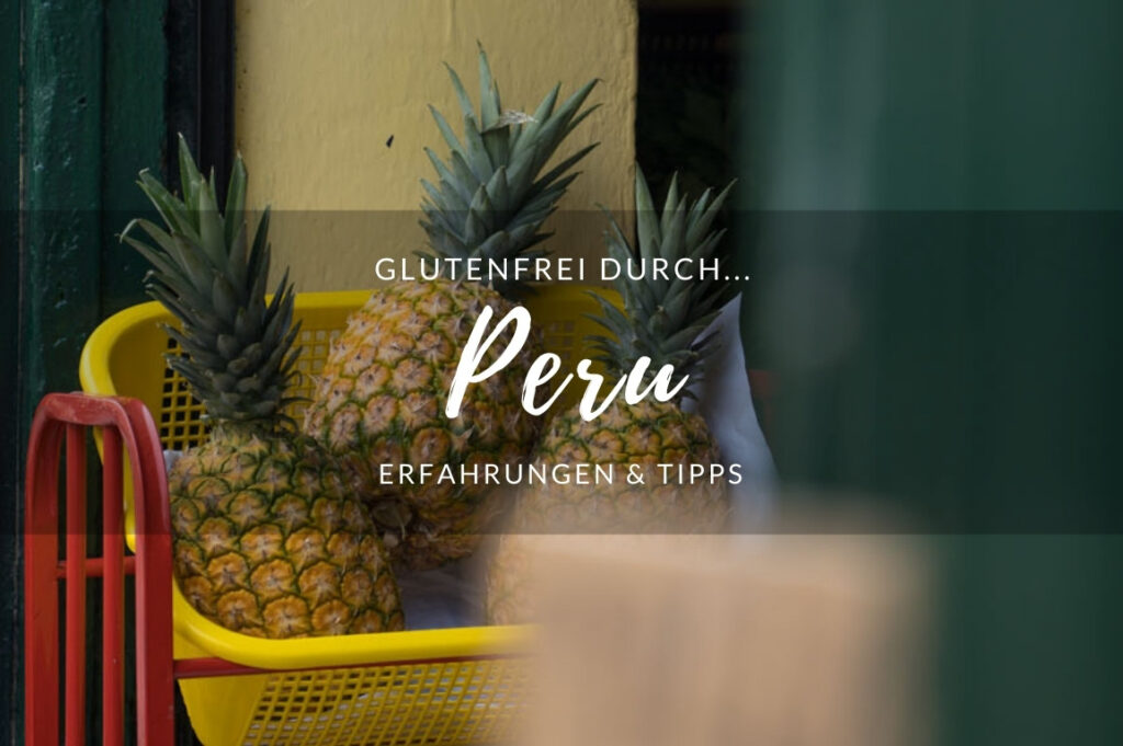 Ananas in einem Regal vor einem Geschäft. Die Hausfassade ist gelb, das Regal rot mit gelben Kisten.