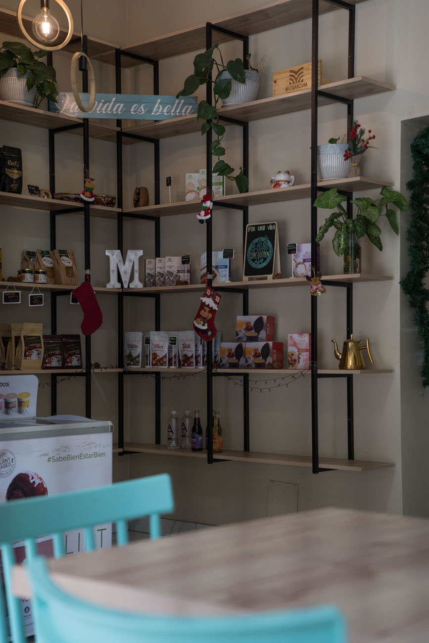 Eine Regalwand in einem glutenfreien Café in Lima, Peru. Man sieht Deko und glutenfreie Backmischungen.