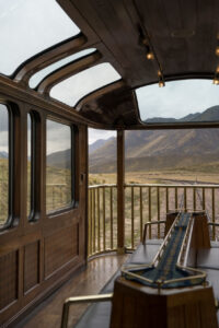 Der Ausblick auf eine weite Landschaft in Peru von dem hintern Waggon einer Bahn.