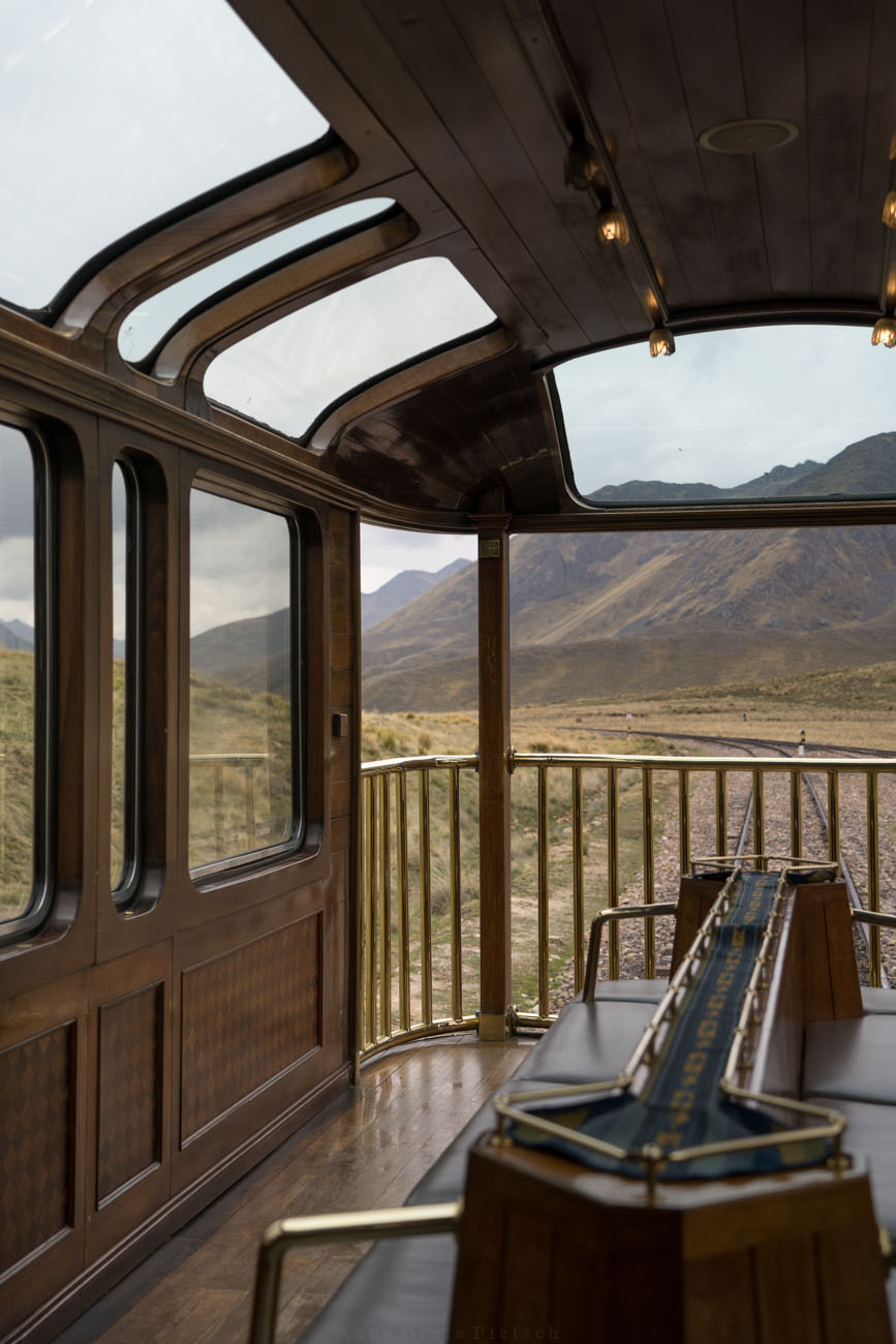 Der Ausblick auf eine weite Landschaft in Peru von dem hintern Waggon einer Bahn. 
