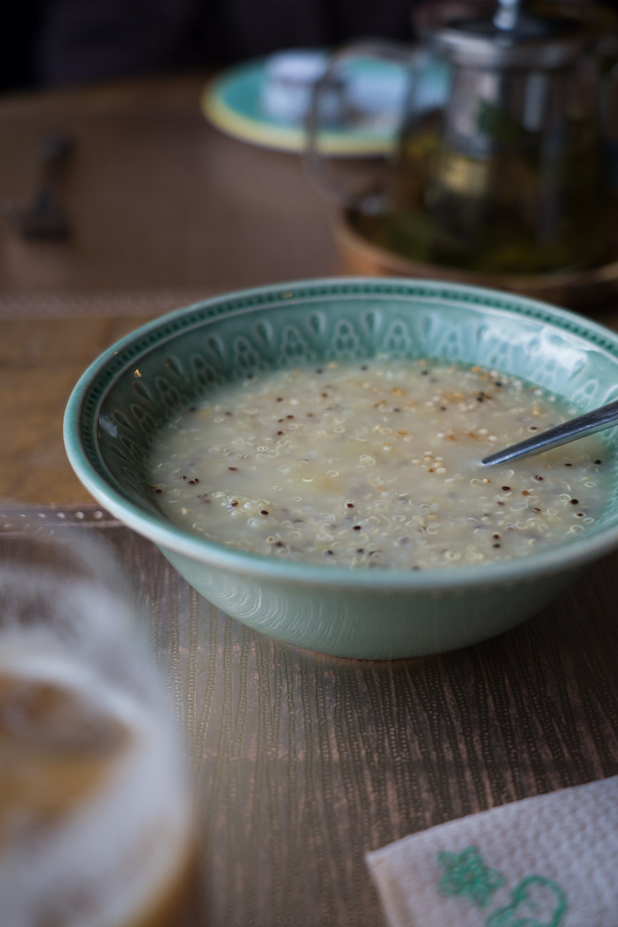 Eine blaue Schüssel mit einem typischen peruanischen Frühstück: eine Art Porridge/Suppe aus Quinoa mit Gewürzen und Apfel.