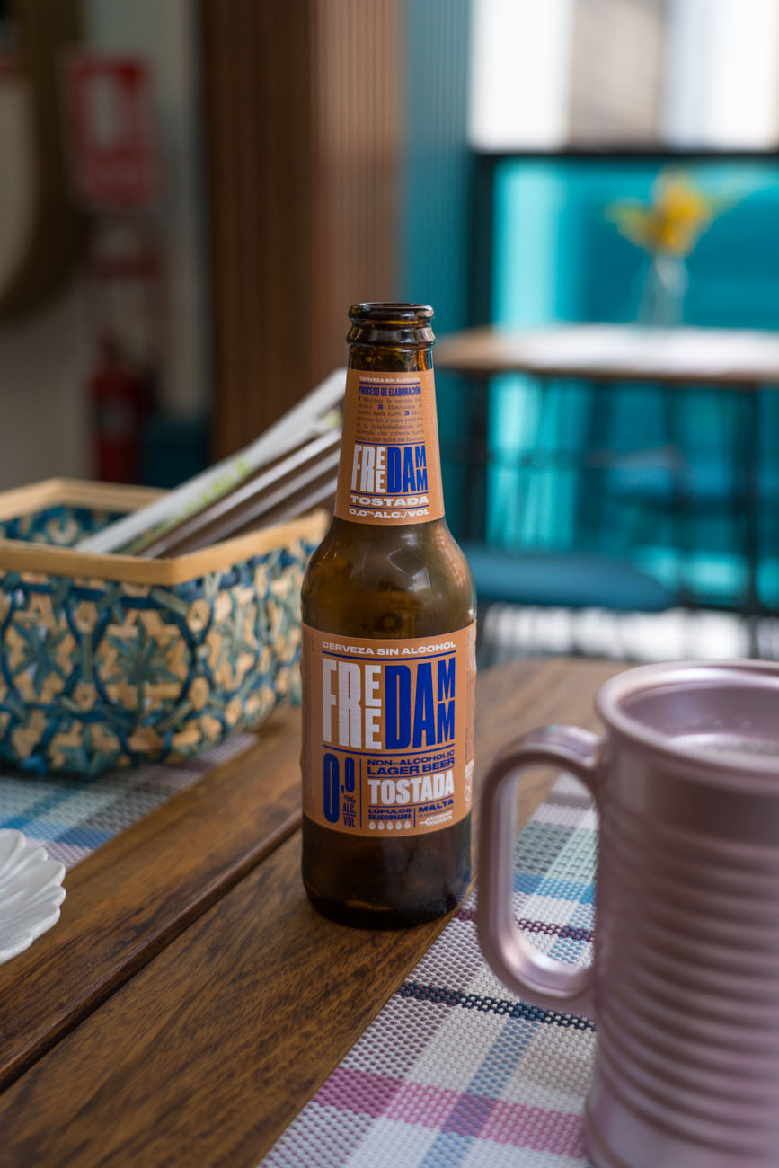 Ein gedeckter Holztisch mit einer Flasche Bier in der Mitte.