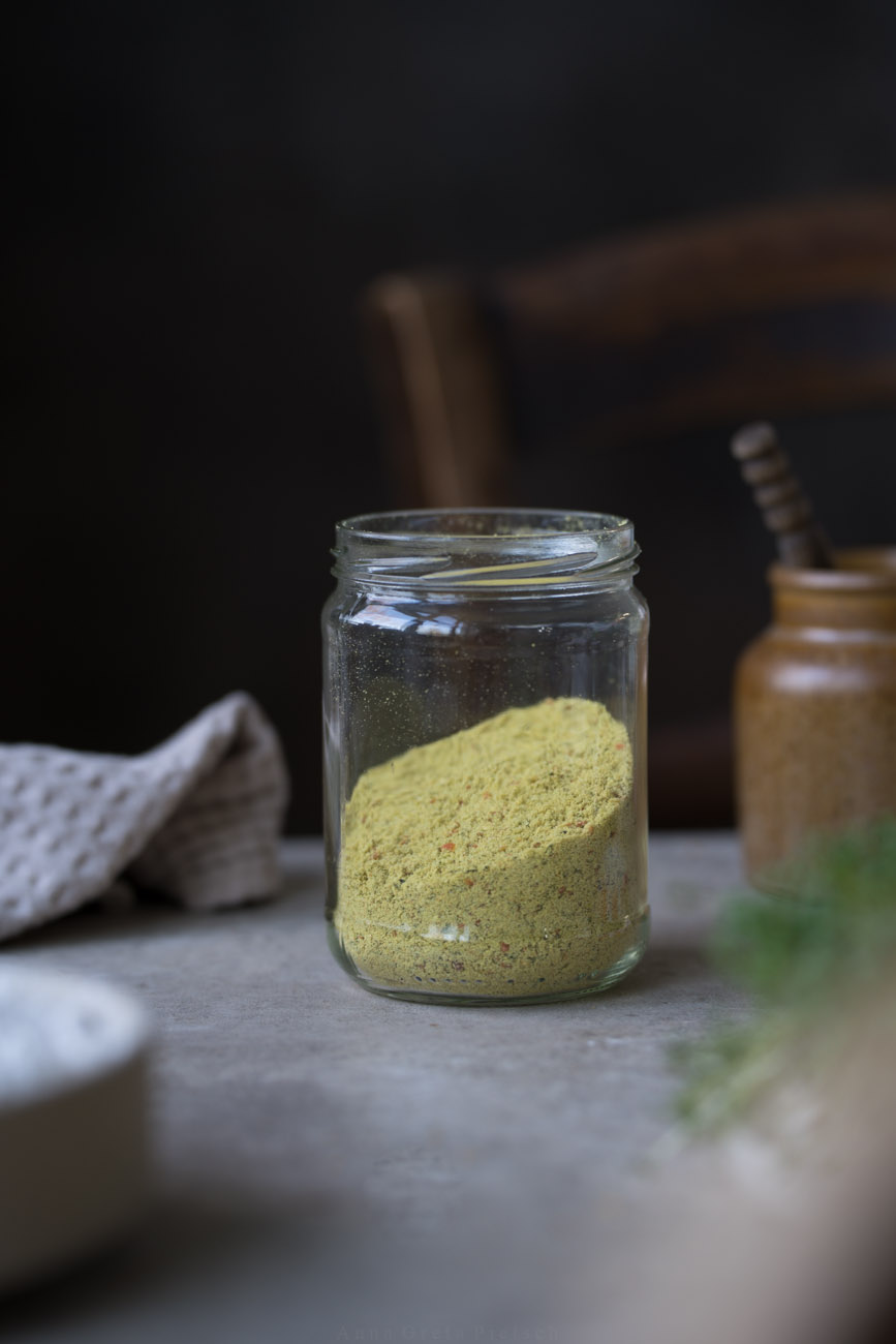 Ein Vorratsglas, das zur Hälfte mit Gemüsebrüge gefüllt ist steht auf einer Arbeitsfläche.