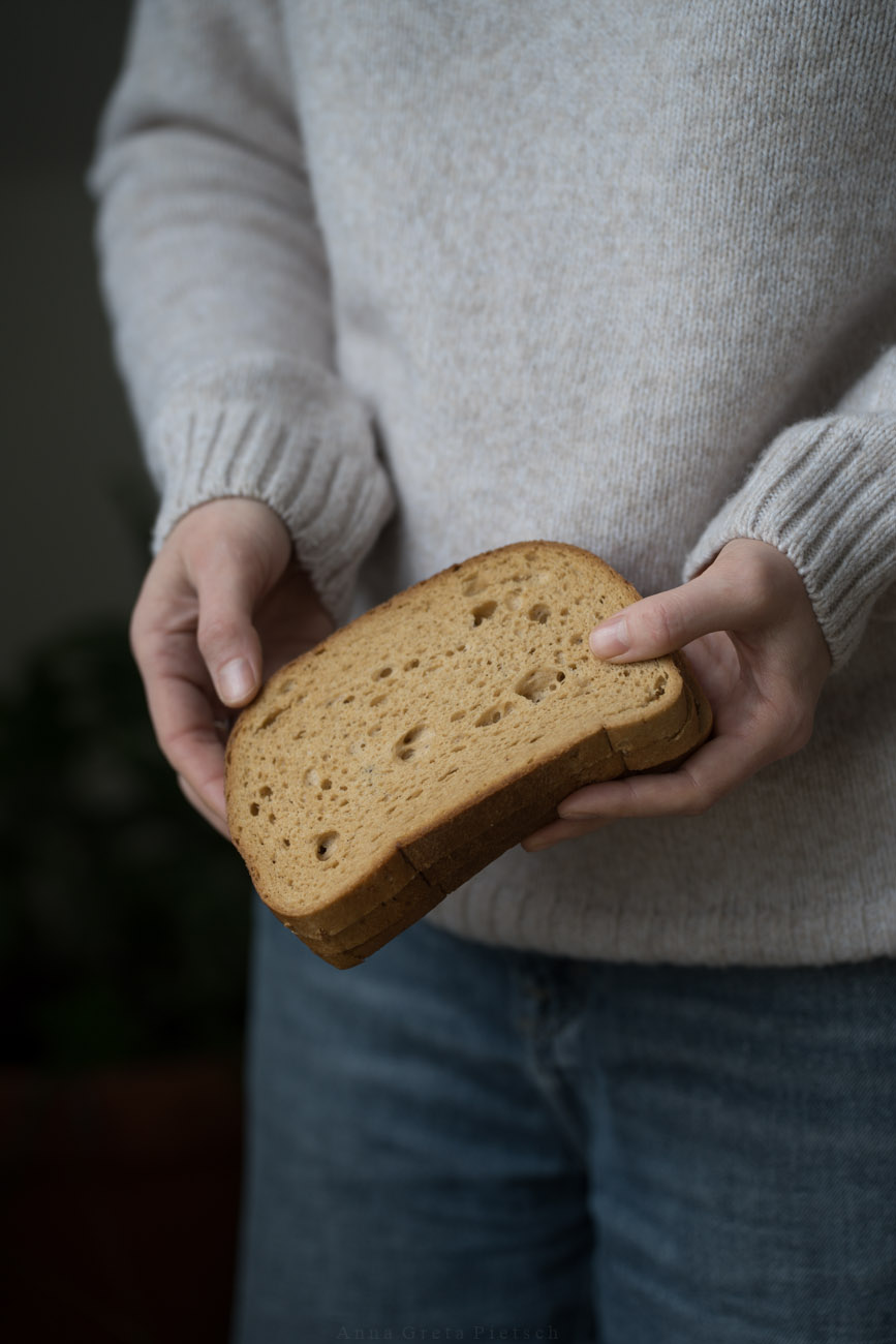 Eine Person hält zwei Scheiben Brot in beiden Händen.