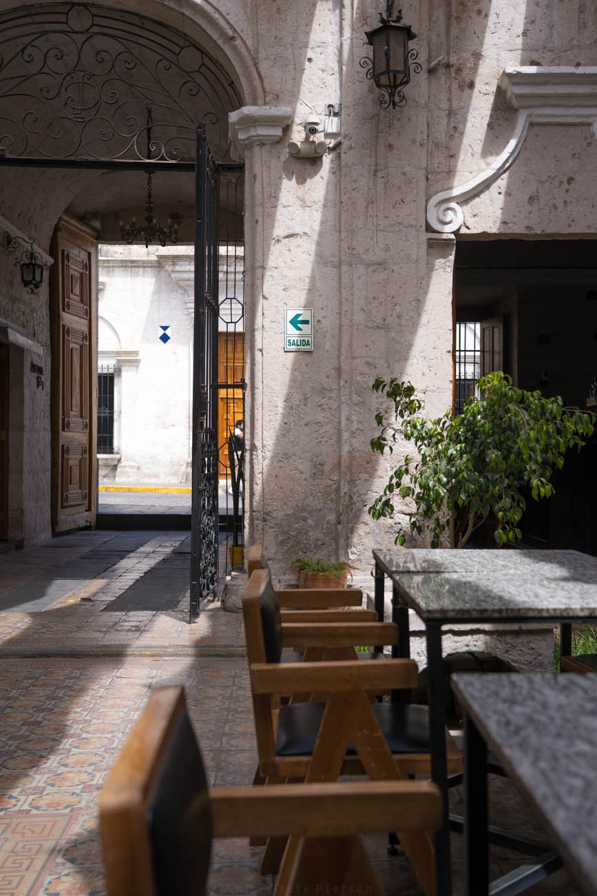 Man sieht einen Innenhof mit mehreren Tischen von einem Restaurant.