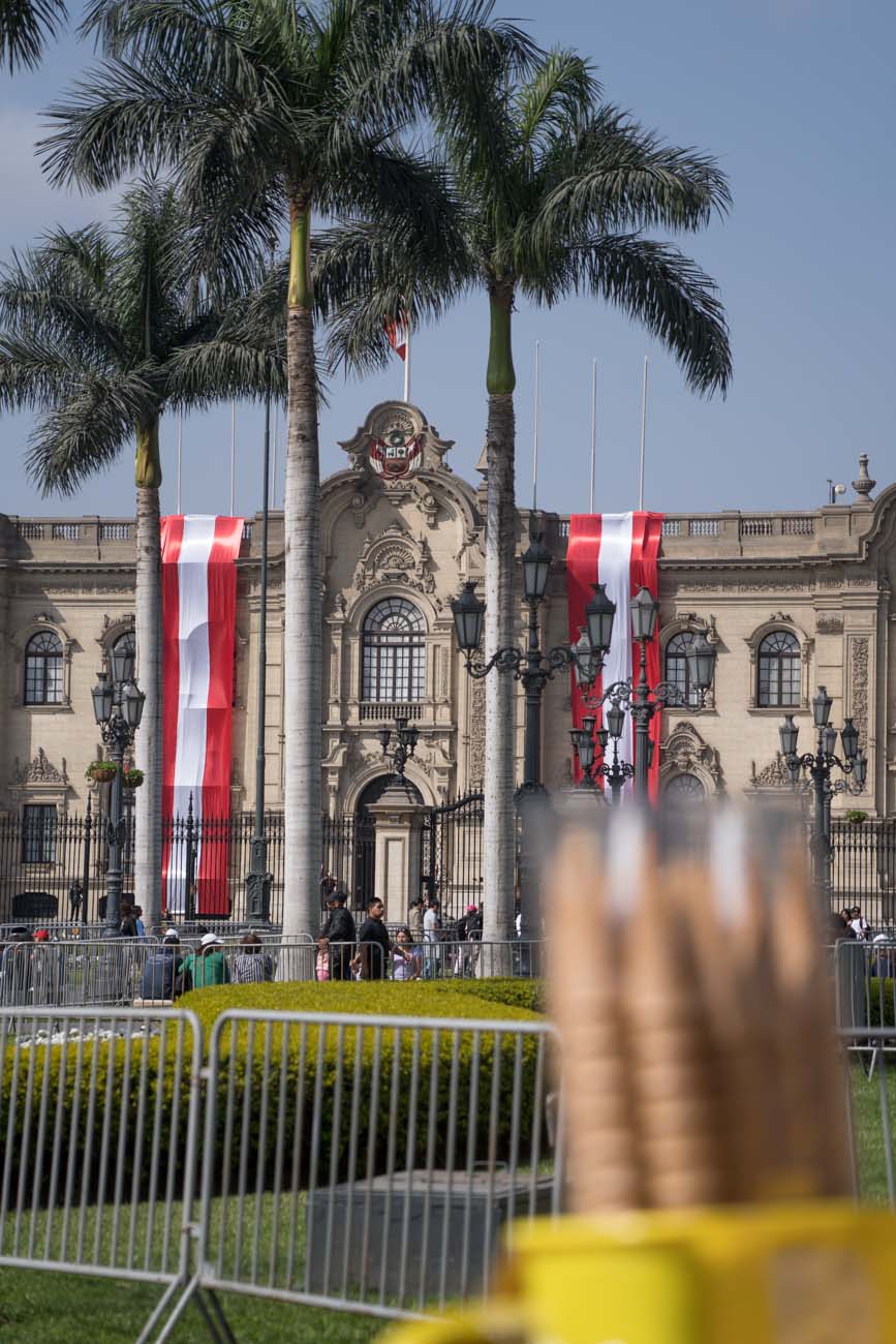 Der Plaza de Armas in Lima, Peru. Am Gebäude hängen peruanische Flaggen.