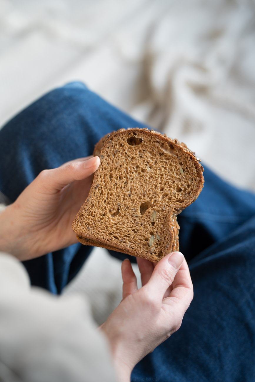 Eine Person hält eine Scheibe Brot in den Händen.