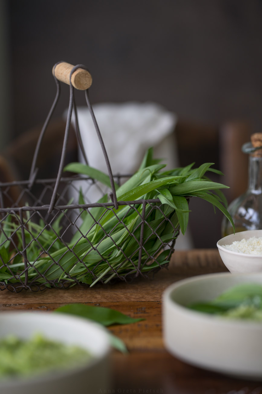 Ein Körbchen mit frischem Bärlauch auf einem Tisch.