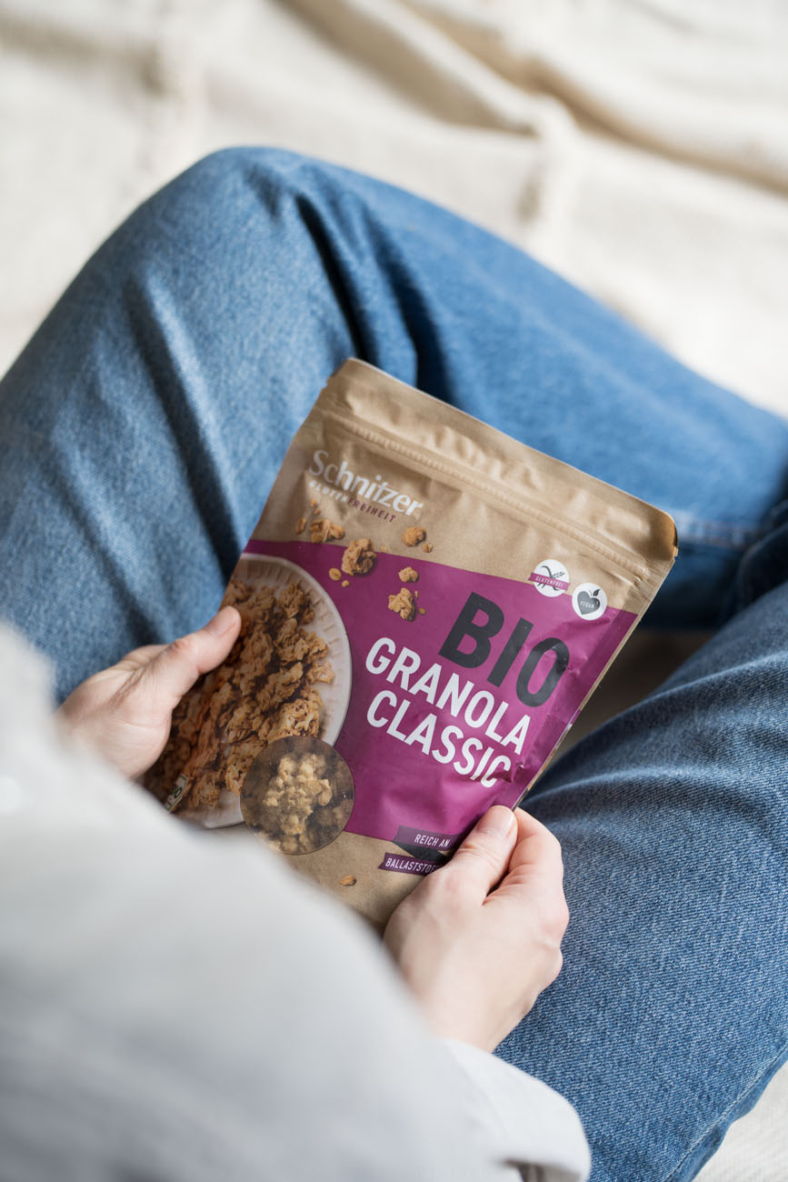 Eine Person hält eine Verpackung Bio Granola Classic in den Händen.