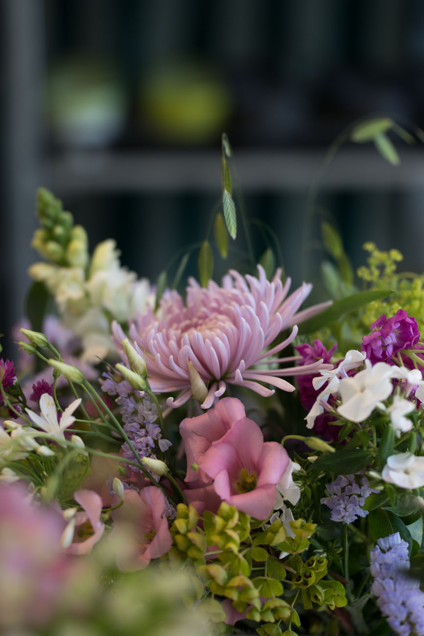 Ein Marktstand mit Blumen. Ein Blumenstrauß ist von Nahem fotografiert.