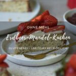 Ein Stück Erdbeerkuchen auf einem kleinen Teller steht in der Mitte einer Kaffeetafel. Man sieht im Hintergrund und Vordergrund noch weitere Kuchenstücke, den Kuchen auf einer Kuchenplatte, Erdbeeren und einen roten Espressokocher.