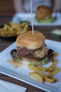Ein saftiger, glutenfreier Burger auf einem weißen Teller.