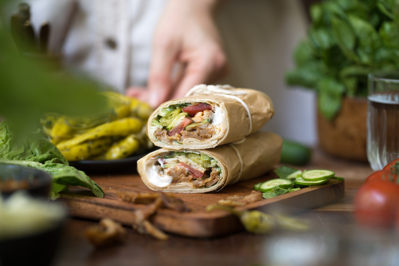 Eine Holztischplatte mit zwei aufeinander getapelten Wraps.