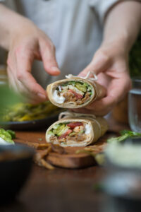 Eine Holztischplatte mit zwei aufeinander getapelten Wraps.