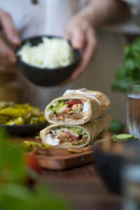 Eine Holztischplatte mit zwei aufeinander getapelten Wraps.