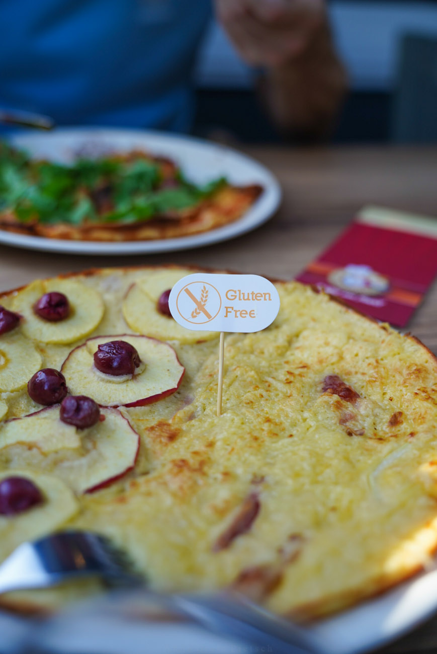 Pfannekuchen auf einem Teller mit Apfelscheiben belegt. Im Hintergrund sieht man einen weiteren Teller mit Pfannekuchen.