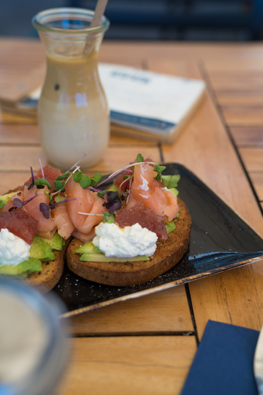Ein glutenfreies Brot mit Lachs und Avocado auf einem Teller.