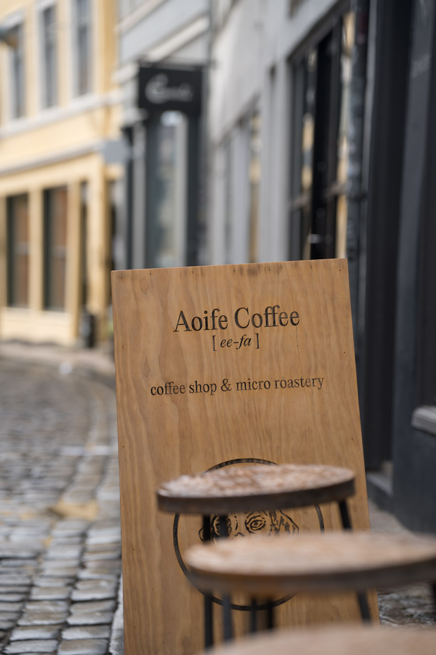 Ein klappbares Holzschild vor einem Laden mit dem Namen des Cafés "Aoife Coffee" in Aarhus, Dänemark.