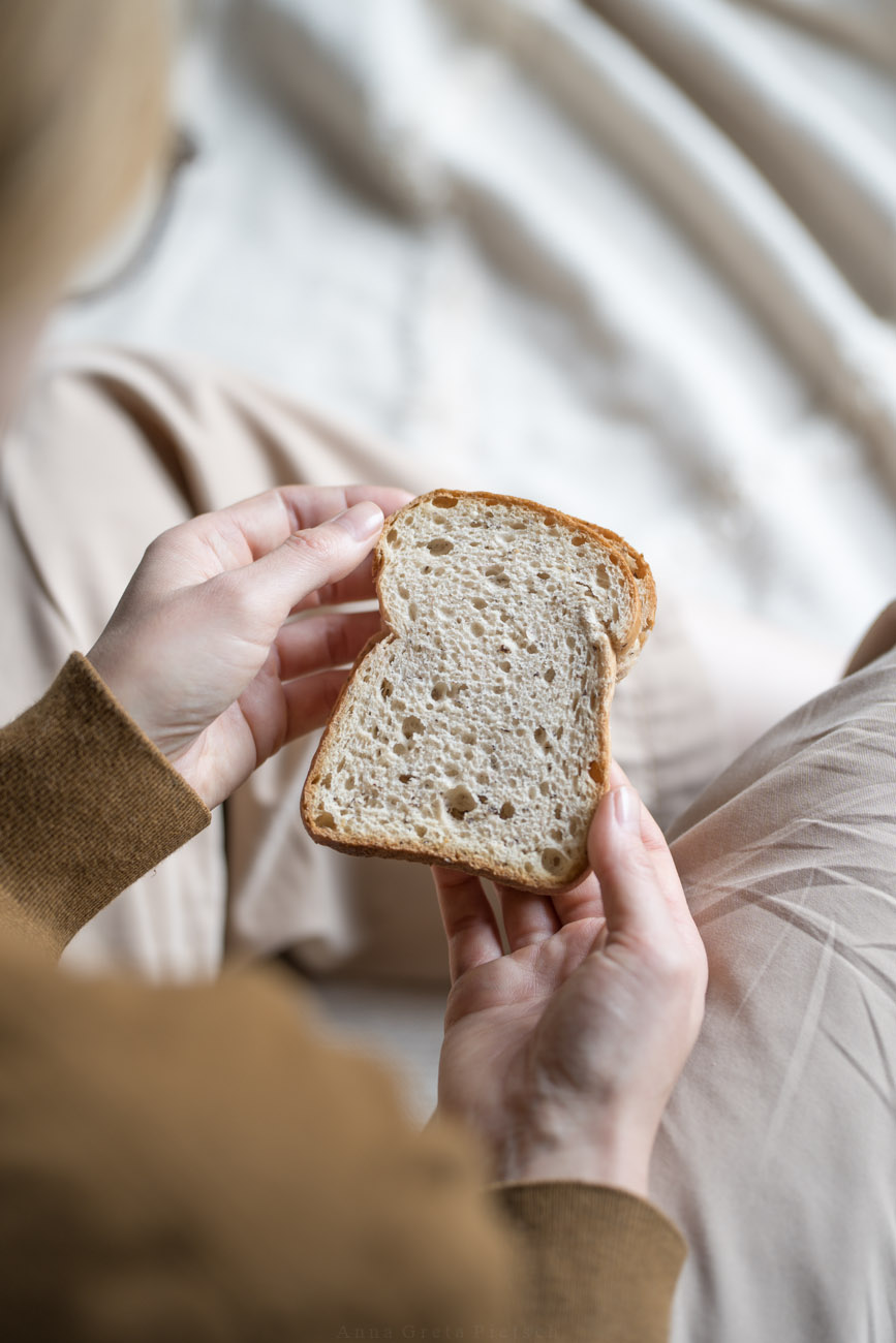 Eine Person hält eine Scheibe Brot in den Händen.