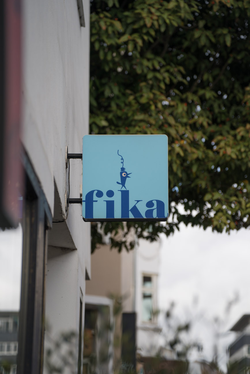 Ein Schild an einer Hausfassade mit dem Namen des Cafés "Fika" in Aarhus.